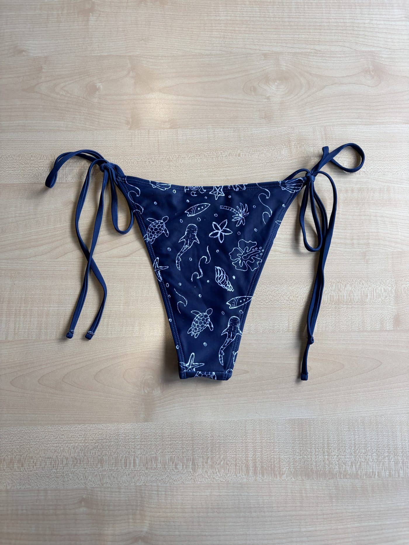 The Oceania bikini bottom, navy with a hand-drawn ocean print